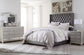 Coralayne King Upholstered Bed with Mirrored Dresser and Nightstand